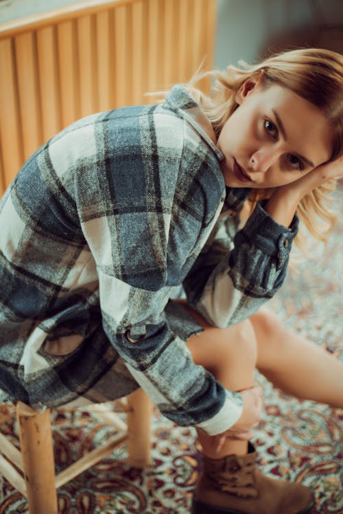 Pretty Woman in Plaid Shirt Sitting on a Stool