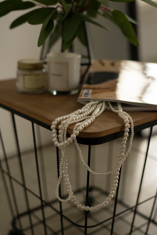 Free Decorative pearls elegantly displayed on a table with magazines and candles, creating a chic and modern vibe. Stock Photo