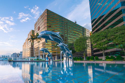 建筑物附近的水的三个蓝海豚雕像前面
