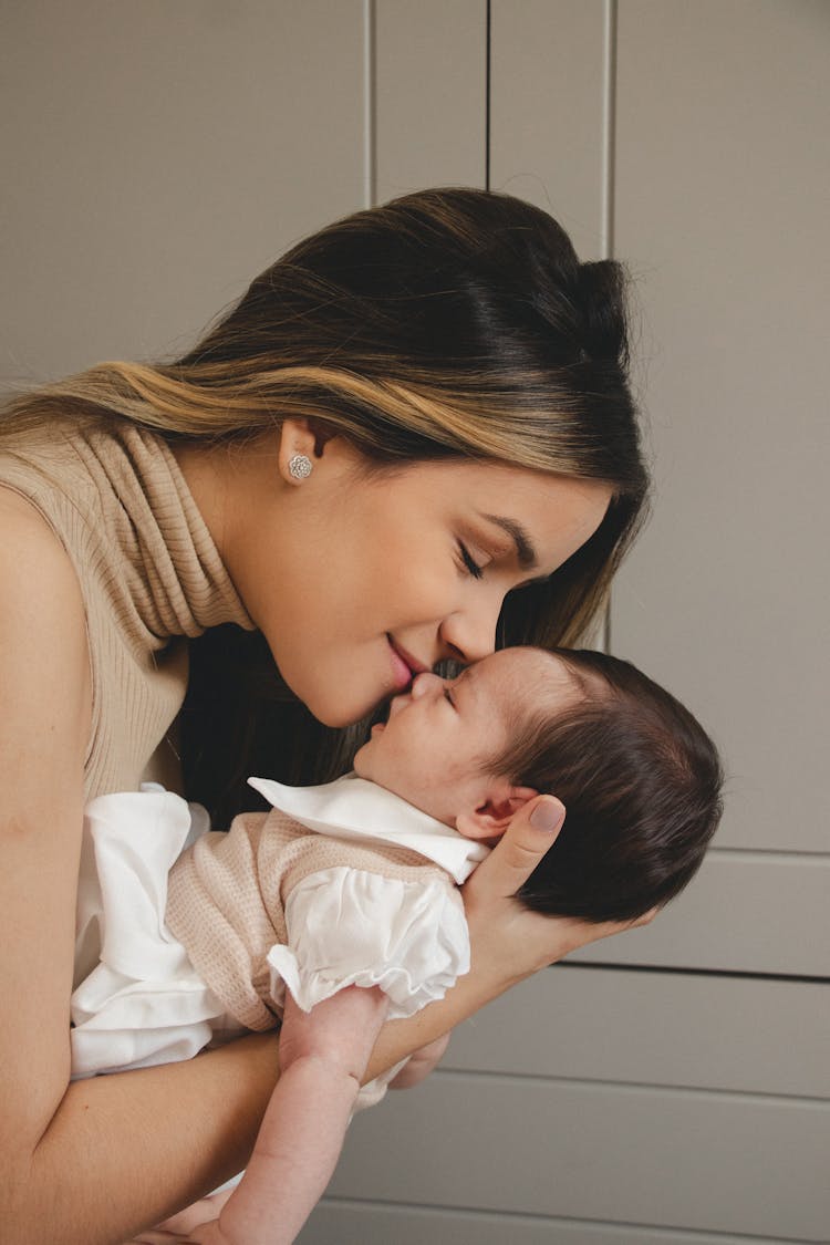 Young Mother Kissing Newborn Baby