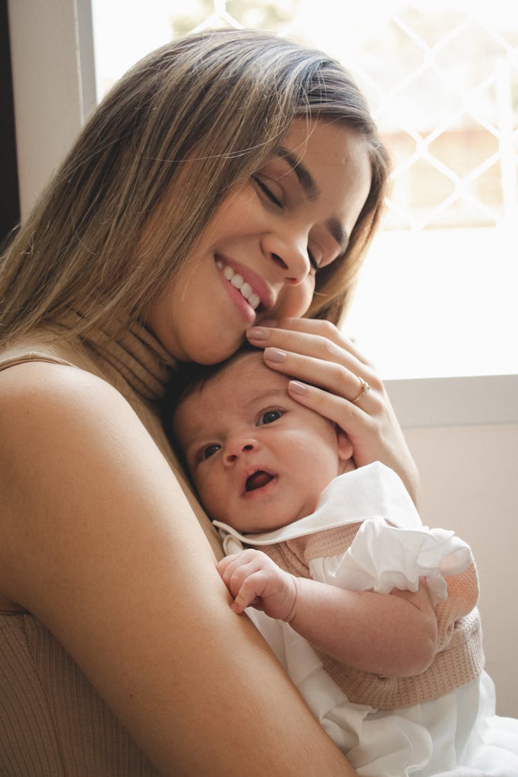 A Smiling Woman Carrying Her Baby