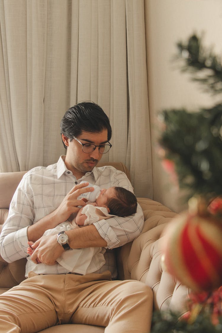 Young Father Feeding Newborn Baby