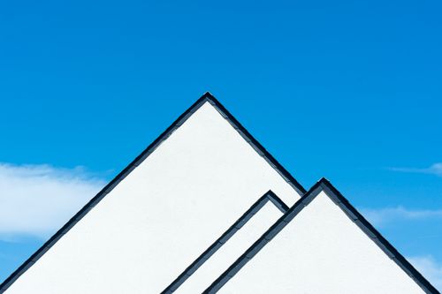 White gable roofs meeting a clear blue sky — photo by Jan van der Wolf on Pexels