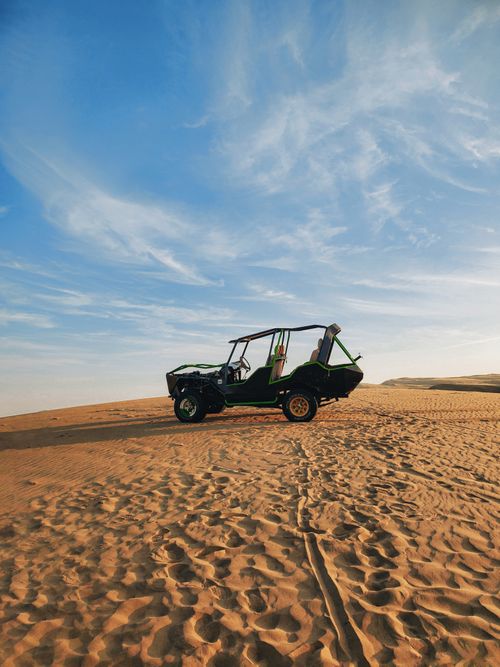 Free ATV parked on a desert dune under a clear blue sky, showcasing adventure and travel themes. Stock Photo