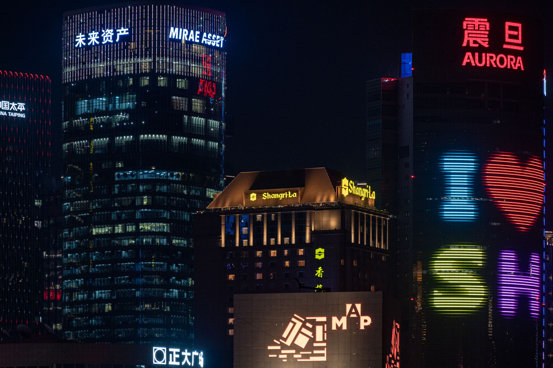 Vibrant Shanghai cityscape with skyscrapers lit up in neon at night.