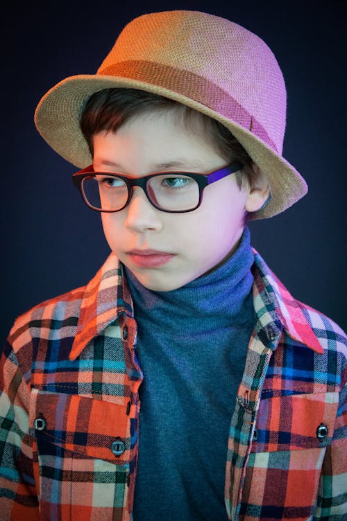 A Boy Wearing Eyeglasses and Fedora Hat 