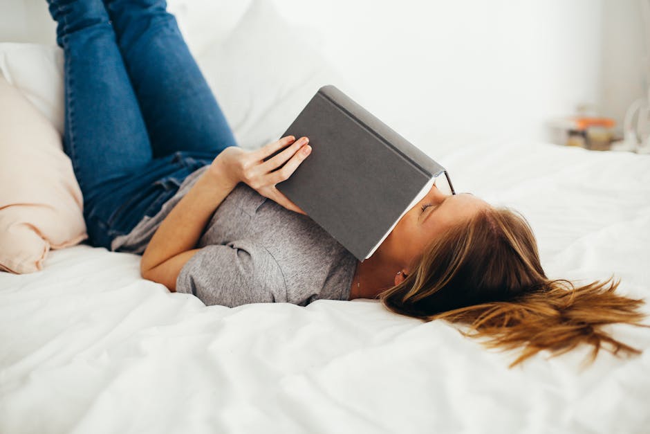 Woman Lying on Bed Holding Book