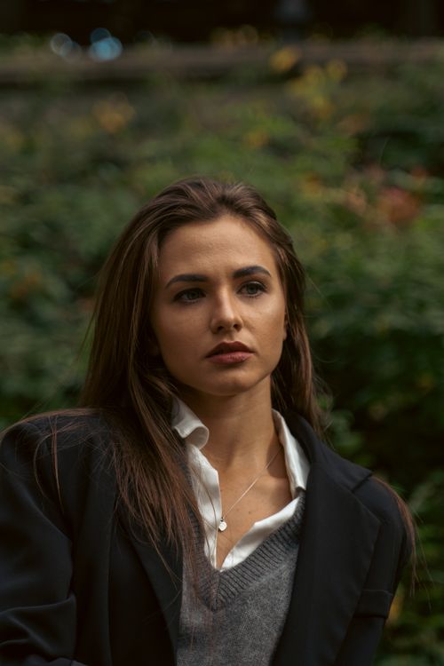 Free Fashionable woman in black blazer and gray sweater posing outdoors in New York City. Stock Photo