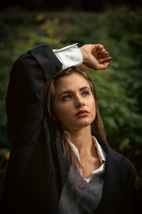 Free Elegant portrait of a woman posing with a moody expression in an outdoor setting. Stock Photo