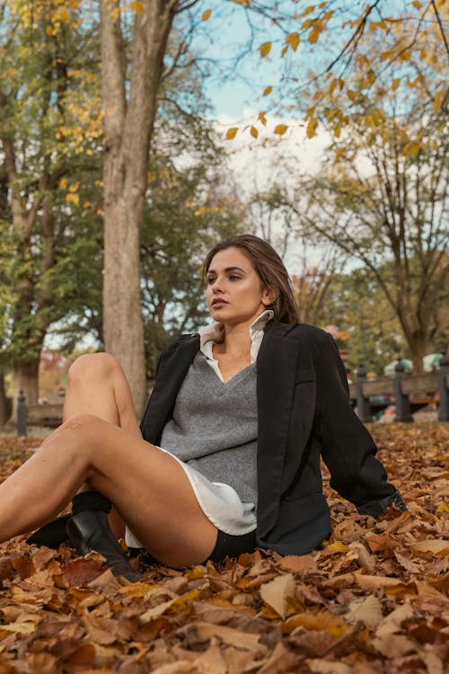 A Beautiful Woman in Black Blazer Sitting on the Field