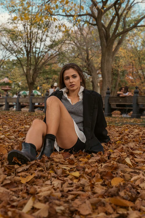 A Pretty Woman in Black Blazer Sitting on the Field