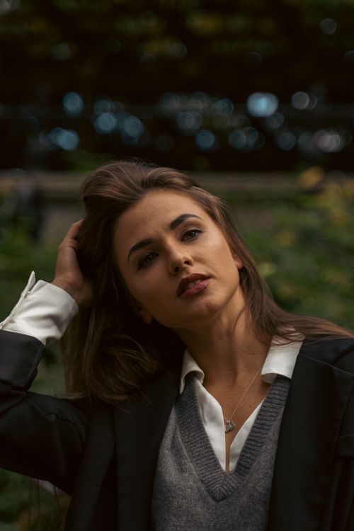 Free Portrait of a woman in a black blazer posing outdoors at Central Park, NYC. Stock Photo