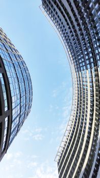 Low-angle view of modern high-rise buildings against a clear blue sky in Warsaw, Poland.
