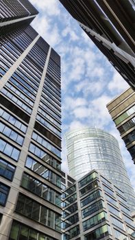 Low-angle view of sleek skyscrapers against a blue sky in Warsaw, Poland.