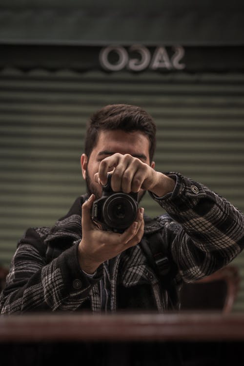 A Man in Black Plaid Jacket Holding a Camera