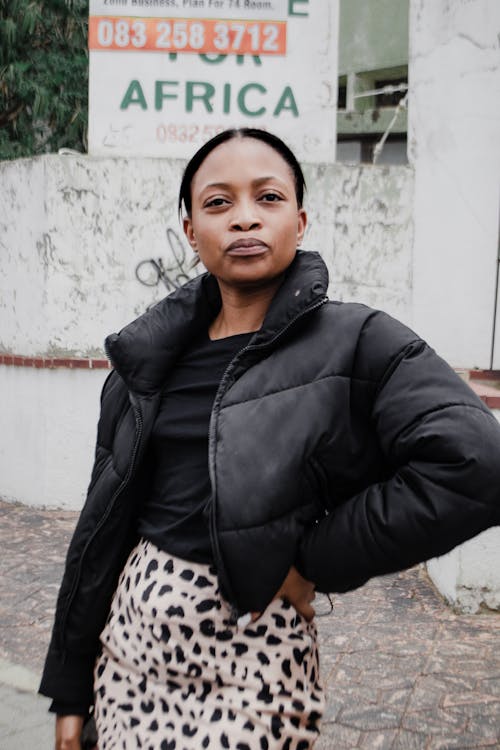 A Woman in Black Coat and Leopard-Print Skirt