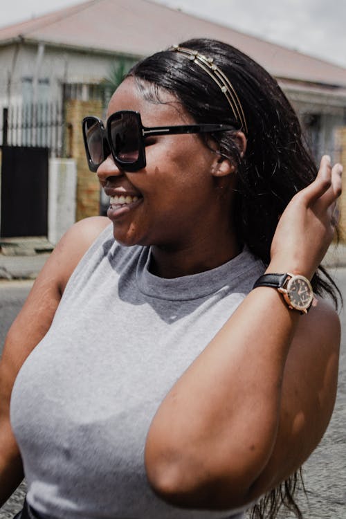 A Woman in Gray Tank Top with Sunglasses Smiling