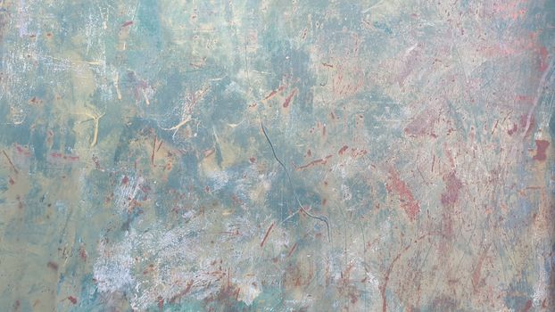 Close-up of an aged wall with peeling paint, showing detailed textures and colors.