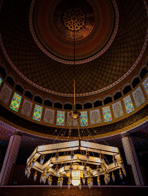 Free Captivating view of an intricately designed mosque ceiling featuring a large ornate chandelier and colorful stained glass. Stock Photo