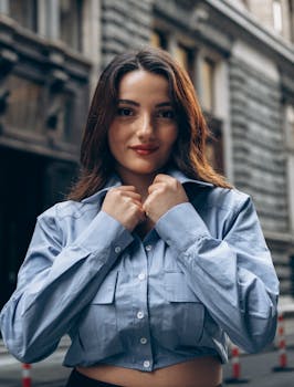 Portrait of a woman in blue shirt standing outdoors in Turkey, exuding confidence.