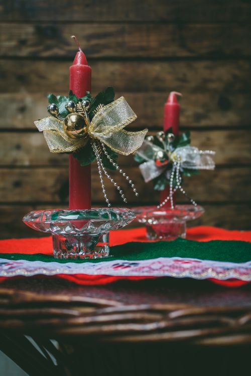 Free Close-up of decorated red candles on a wooden background, perfect for Christmas ambiance. Stock Photo