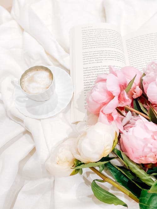 Close-Up Shot of Pink Peonies beside a Book and a Cup of Coffee