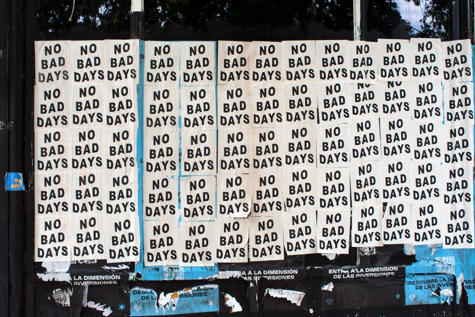 Energetic display of 'No Bad Days' posters on a city wall, conveying positive vibes.