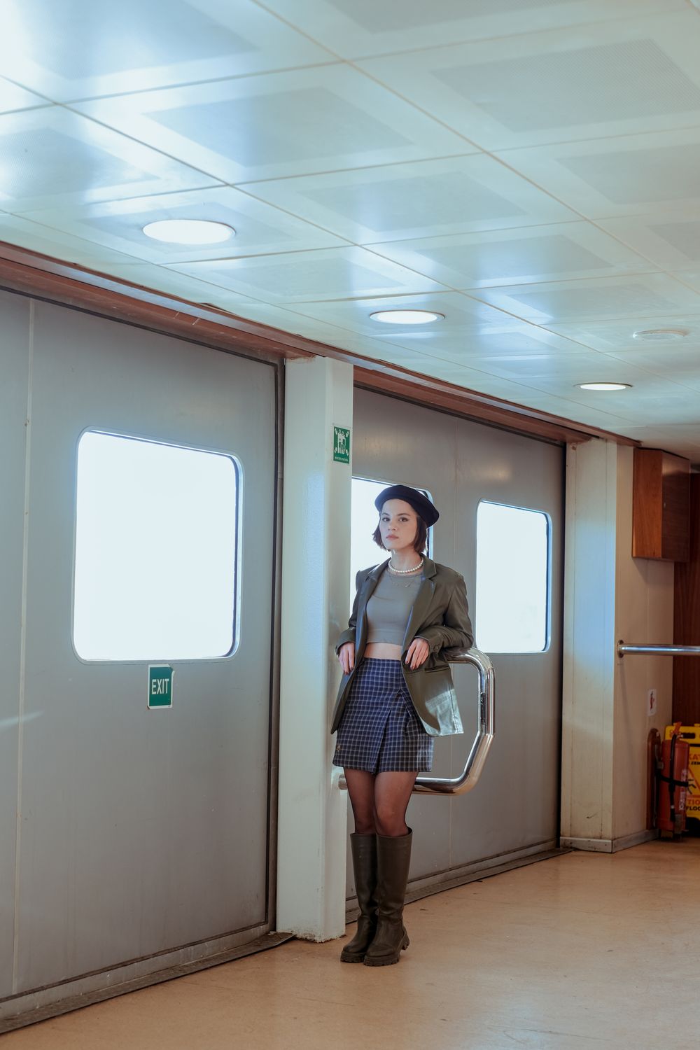 A Woman in Brown Coat and Skirt Standing near the Door · Free Stock Photo
