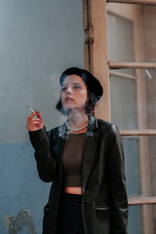 穿大衣戴贝雷帽抽烟的女人