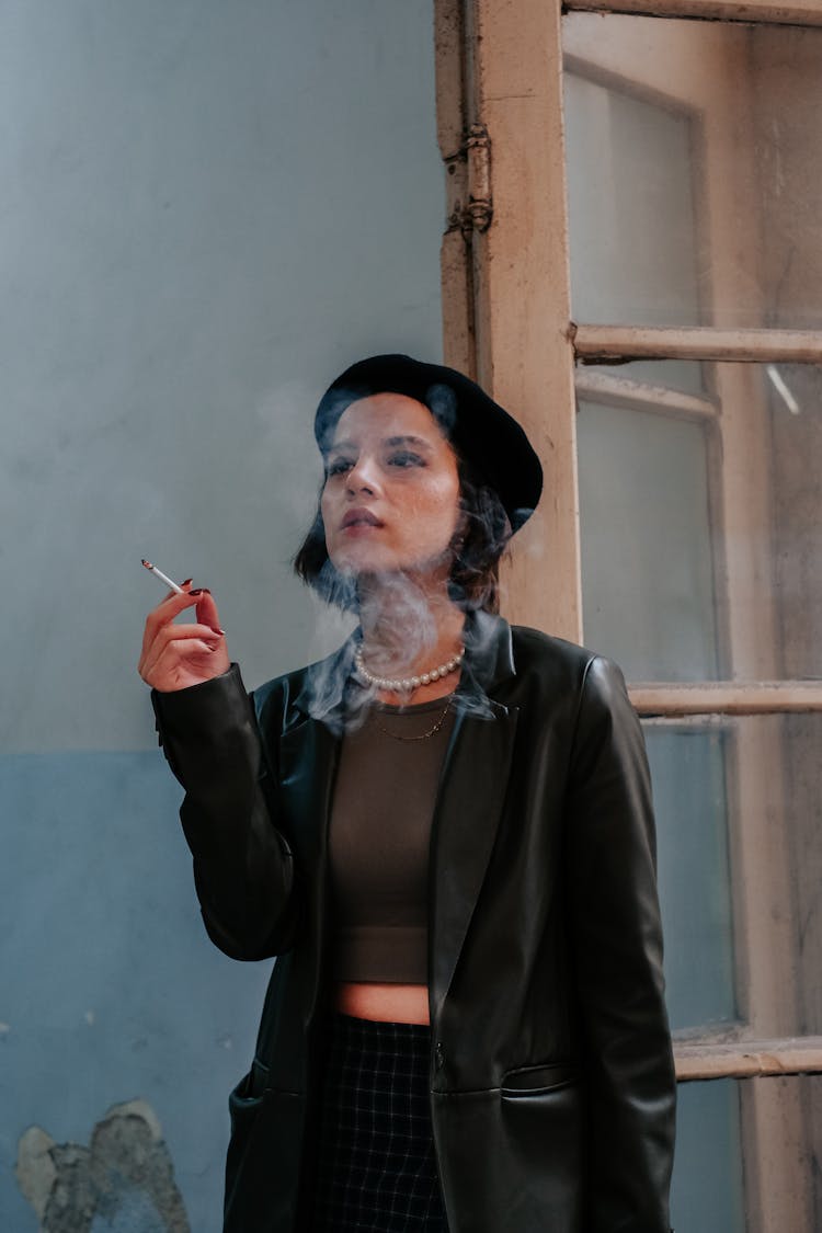 Woman In A Coat And A Beret Smoking A Cigarette