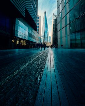 Low angle view of The Shard with pedestrians in London during daytime.