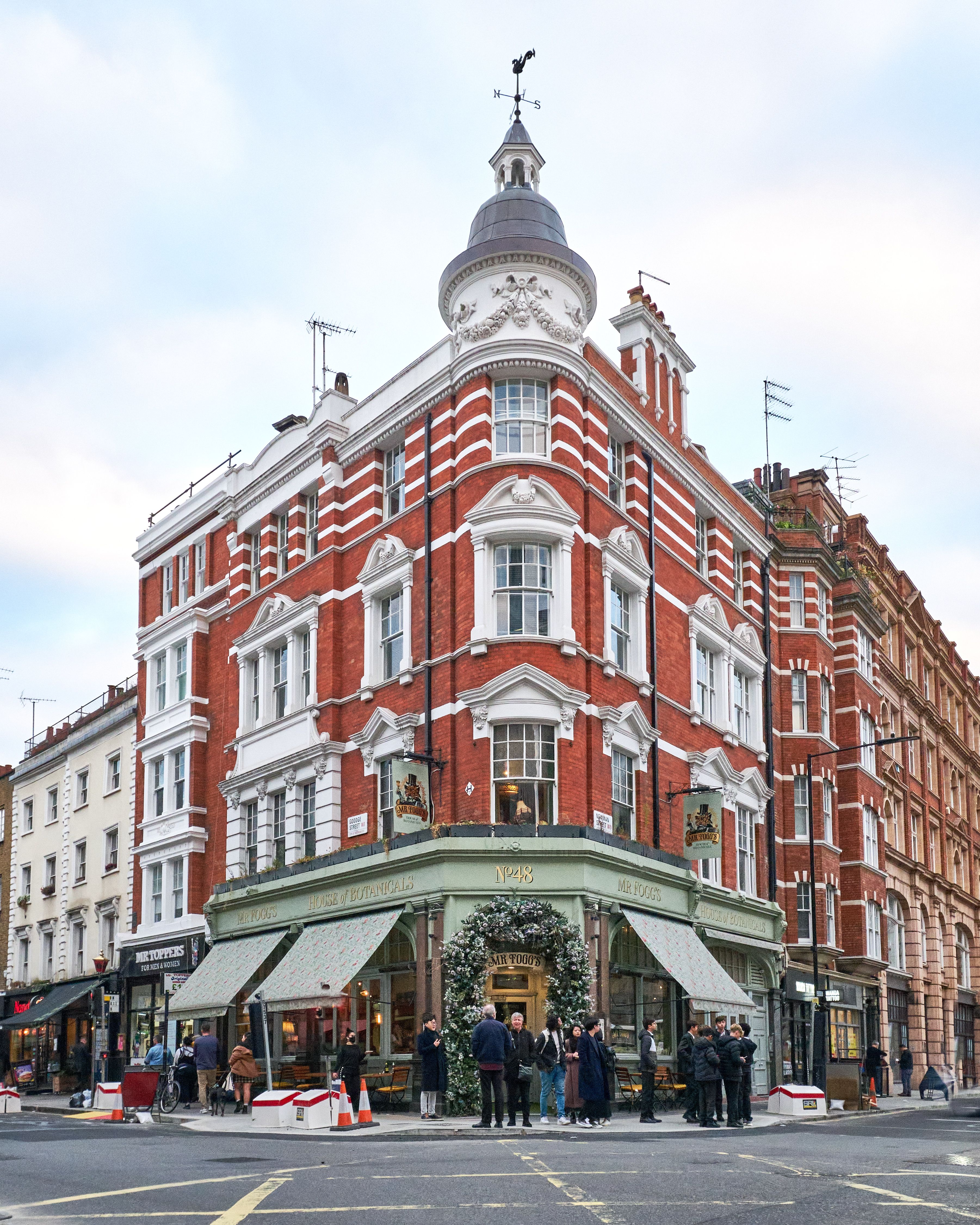 Classic London street scene with red brick architecture and bustling exterior.