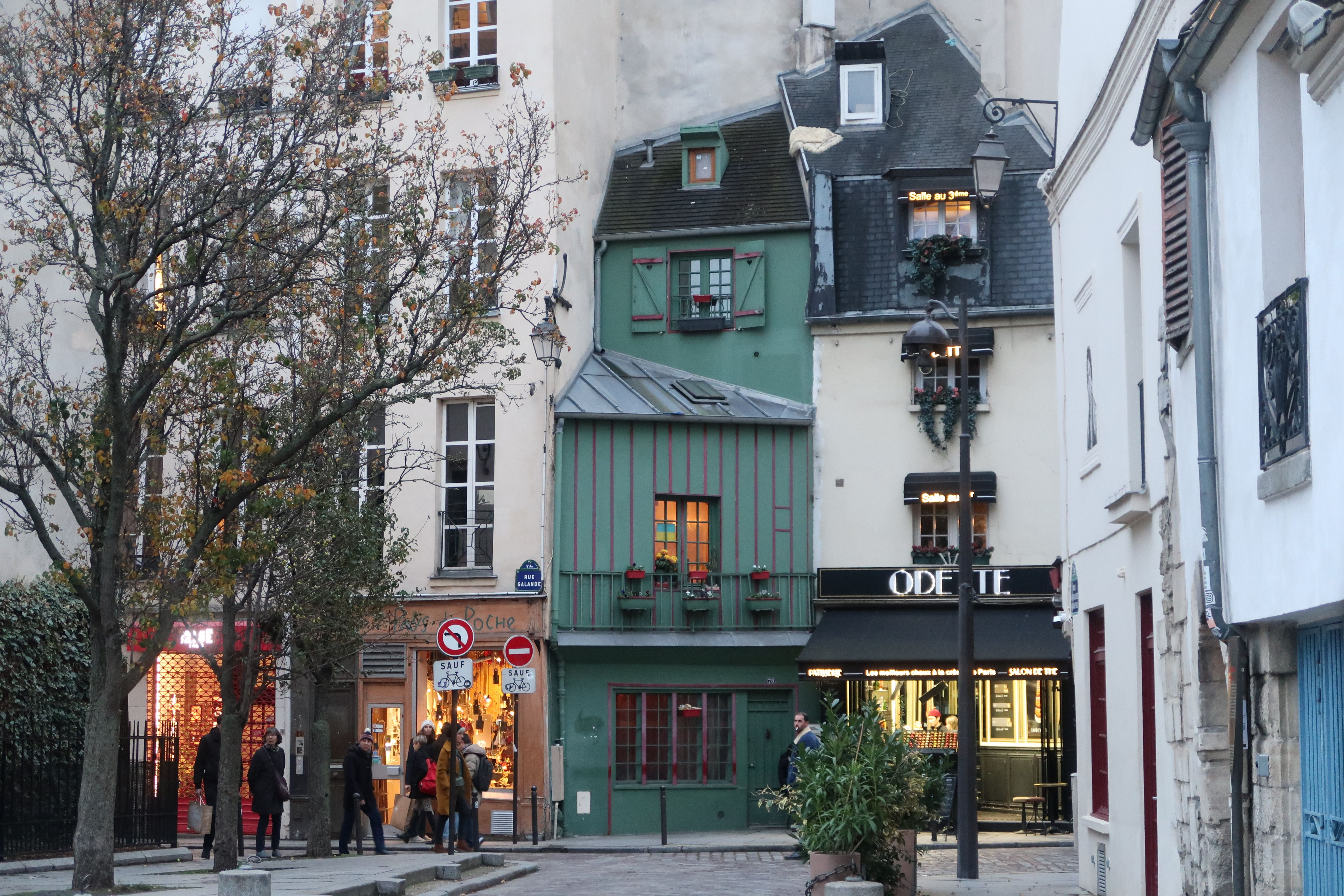 A cozy Paris street lined with historic buildings and a lively crowd enjoying the winter day.