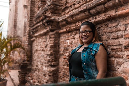 Mujer Recostada Sobre La Pared De Ladrillo Marrón