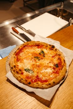 Freshly baked Margherita pizza with basil on parchment, perfect for Italian cuisine lovers.
