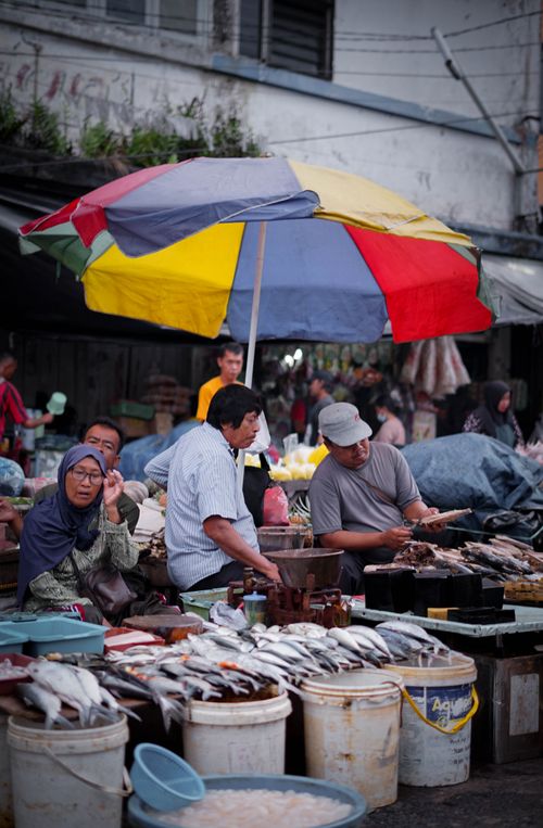Free Bustling street market in Jawa Barat, Indonesia with colorful umbrellas and diverse vendors. Stock Photo