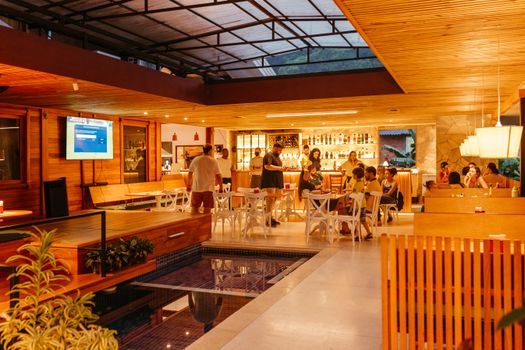 Interior of a bustling restaurant bar with people enjoying a warm evening.