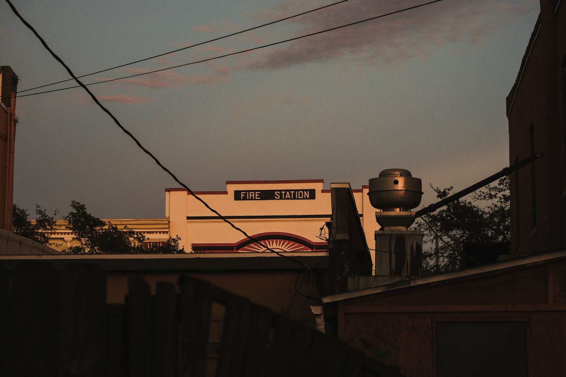 A nostalgic view of an old fire station building at dusk, creating a moody urban atmosphere.