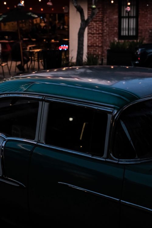 Free Close-up of a vintage car parked outside in dim light, creating a moody atmosphere. Stock Photo