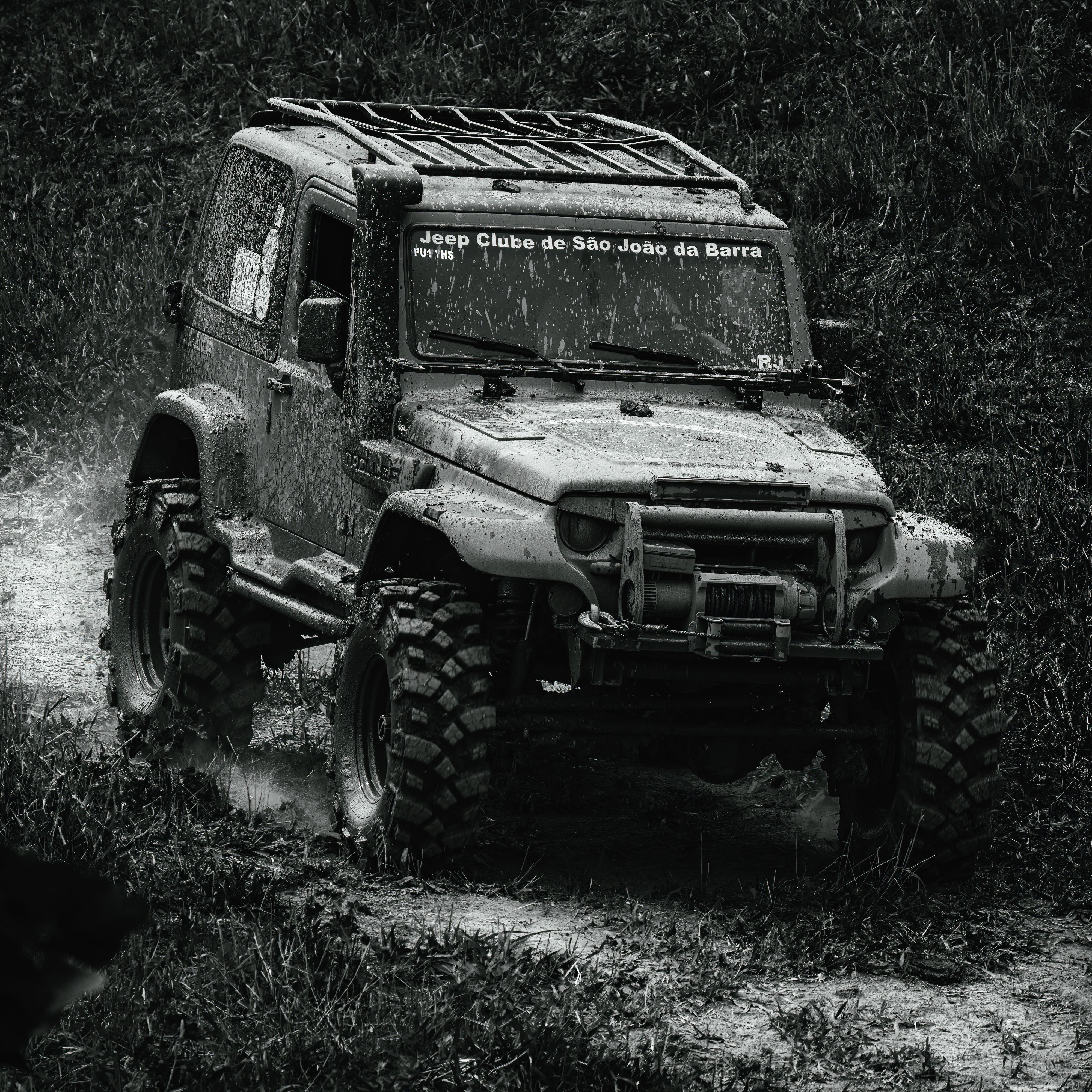 Grayscale Photo of a Car on Dirt Road