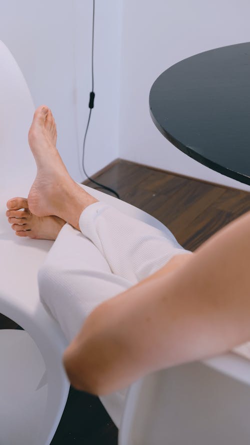 Photo of a Person's Feet on a White Chair
