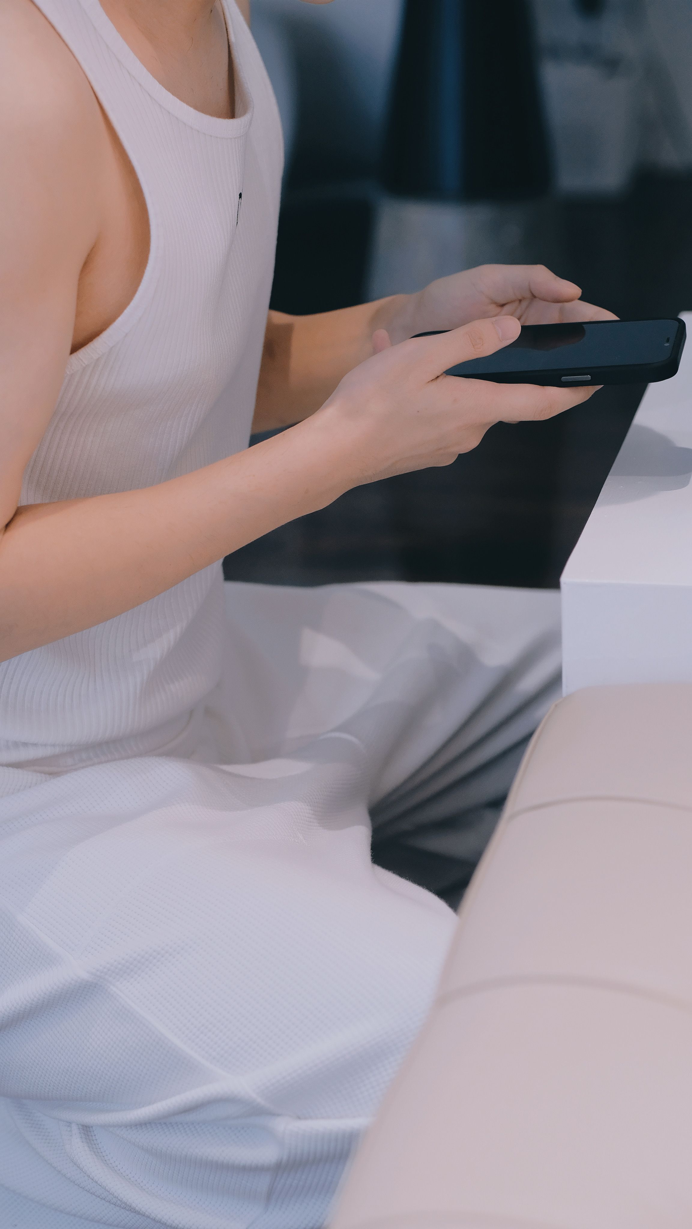 Close-up of a person holding a smartphone in a modern indoor setting, showcasing technology use.