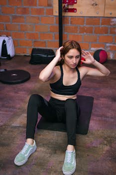 Woman doing sit-ups in a gym, focusing on fitness and healthy lifestyle.