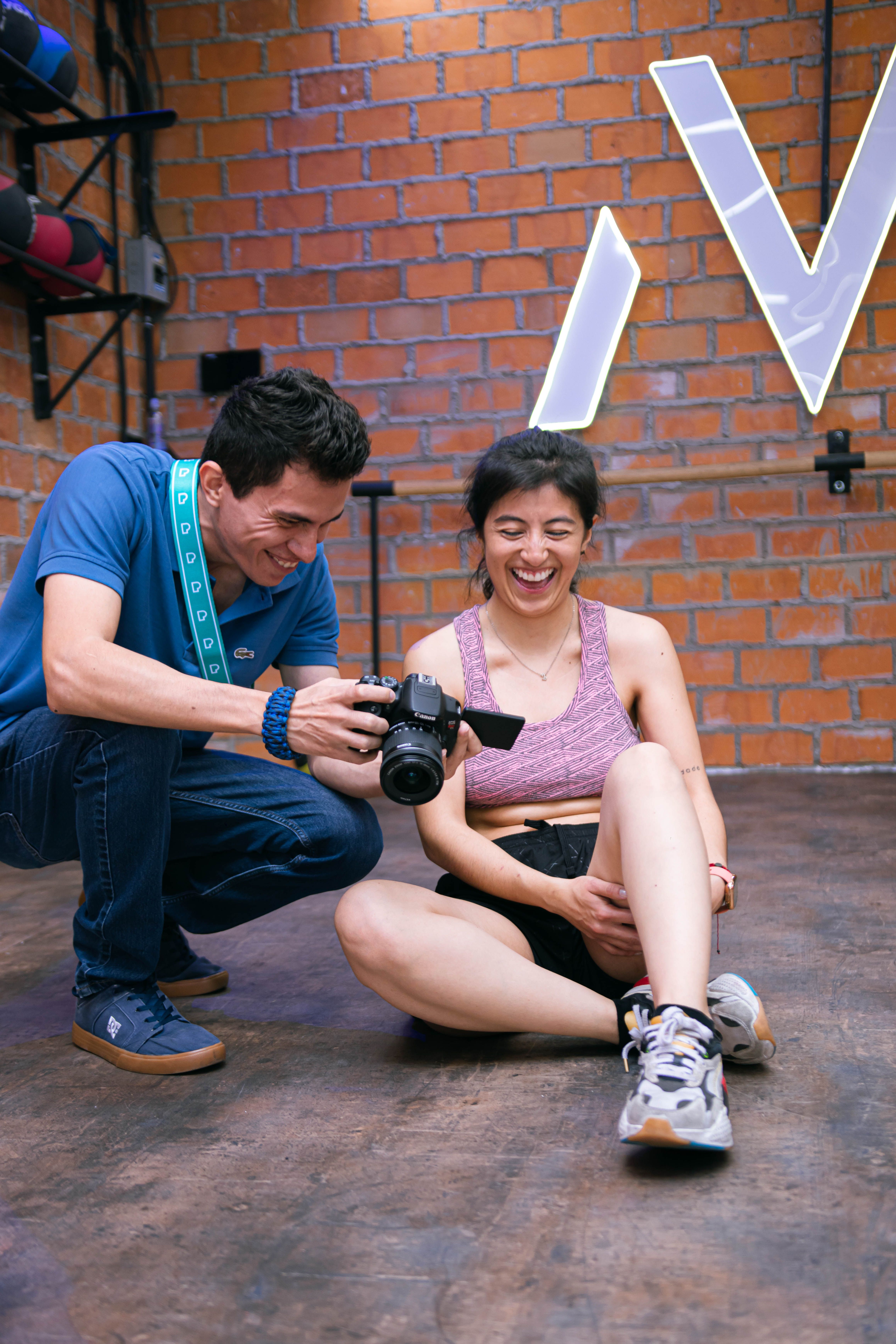 Man and woman sharing a joyful moment during a photography session in an urban gym.