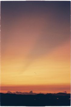 Beautiful sunset sky with warm colors and distant horizon, perfect for serene landscapes.