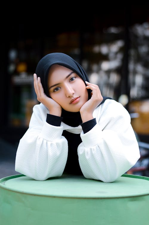 A Woman in Black Hijab Posing while her Hand on Chin