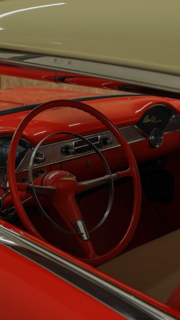 Close-up of a vintage car's red interior in Milan, showing the steering wheel and dashboard.
