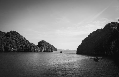 Free Monochrome seascape with islands and boats under a clear sky. Stock Photo