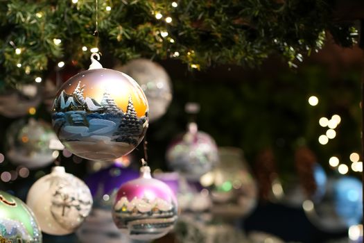 Close-up of beautifully decorated Christmas ornaments hanging from a tree, capturing the festive and winter spirit.