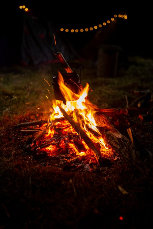 Free Warm campfire burning brightly at night, surrounded by nature. Ideal for outdoor and camping themes. Stock Photo
